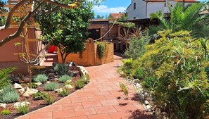 Stroll through the garden pathway to a charming pergola, surrounded by lush greenery and inviting plants.