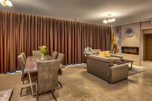 Relax in this stylish living space with a dining area, featuring a sofa, dining table, and flat-screen TV.