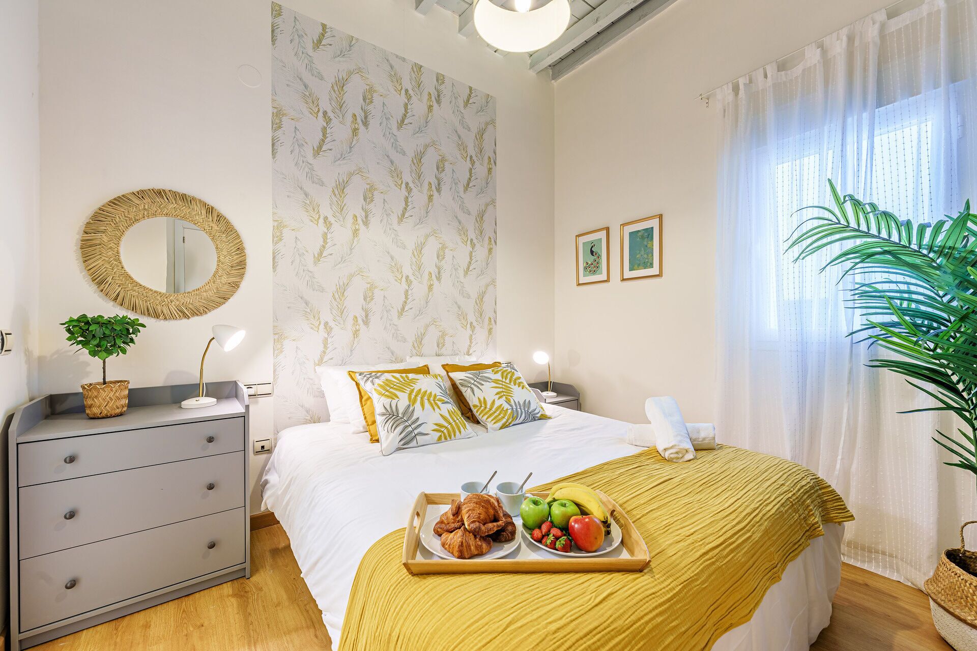 Une chambre à coucher bien rangée, avec un lit, une table de chevet et un plateau contenant divers éléments pour le petit-déjeuner.