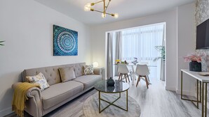 Una sala moderna con sofá, mesa de centro y comedor con sillas y mesa.