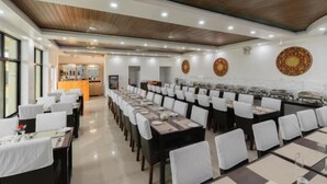 Un amplio comedor con varias mesas y sillas, techo de madera y ambiente luminoso y bien iluminado.