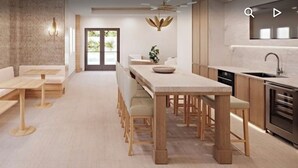A modern kitchen with a central island, wooden benches, and a built-in oven. - Direct large, beachfront Condo, steps to Vanderbilt Beach, 3 bedroom, 3 bath. (Naples)