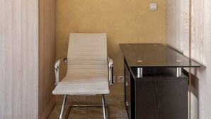 A small room with a beige chair, a black cabinet, and a wooden wardrobe. - Cosy Apartment Rabat center (Rabat)