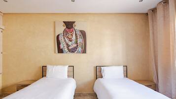 A hotel room with two single beds, a large painting on the wall, and a curtain on the window.