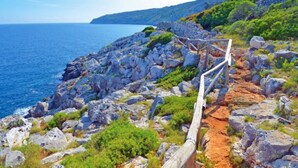 A rocky coastal path with a wooden railing, leading towards the sea. - MOD SALENTO B&B - TWIN BEDROOM (Corsano)