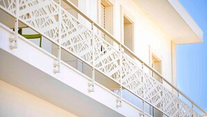 A white staircase with geometric patterns, leading to a balcony with a green chair. - MOD SALENTO B&B - TWIN BEDROOM (Corsano)