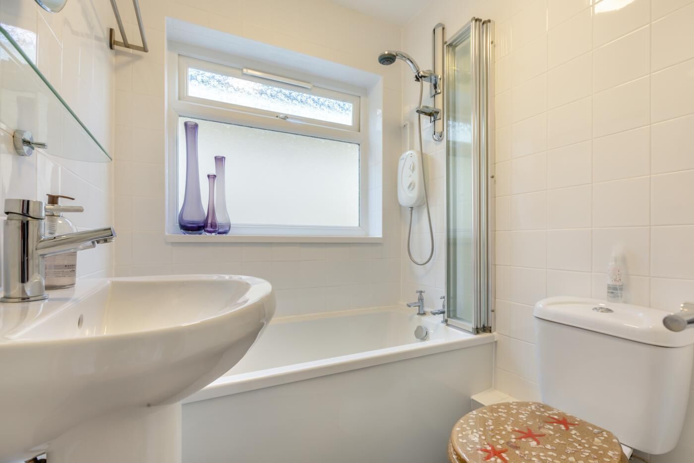 A bathroom with a sink, a bathtub, a toilet, and a shower enclosure.