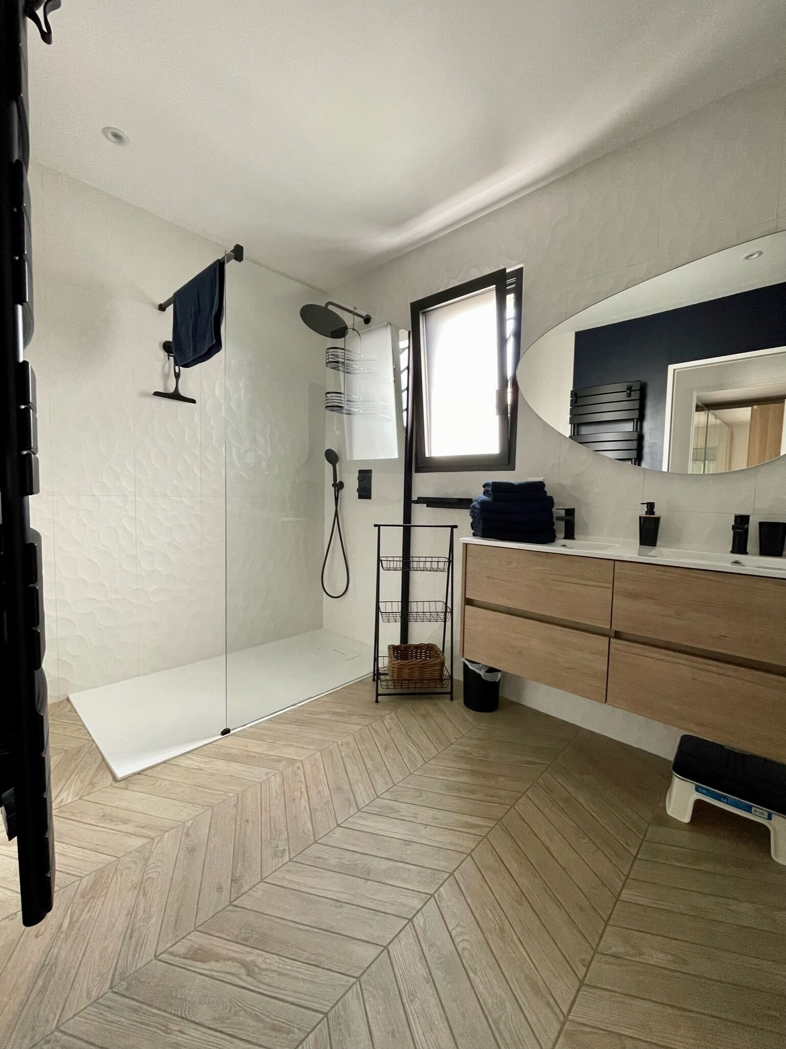 Une salle de bain moderne avec une douche, un meuble-lavabo et un grand miroir.