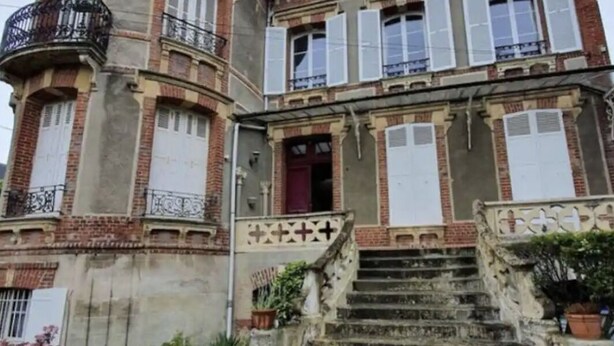 A historic building with a turret, multiple windows, and a staircase leading to the entrance. - Cabourg Plein Centre - Appartement Douillet et Lumineux (Cabourg)
