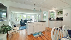 A spacious kitchen with white cabinetry, a large island, and pendant lighting. - Bayfront Villa:  Dock, Walk to Beach and Bridge Street (Bradenton Beach)