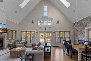 Un loft spacieux avec de hauts plafonds, de grandes fenêtres, une cheminée et un coin repas.