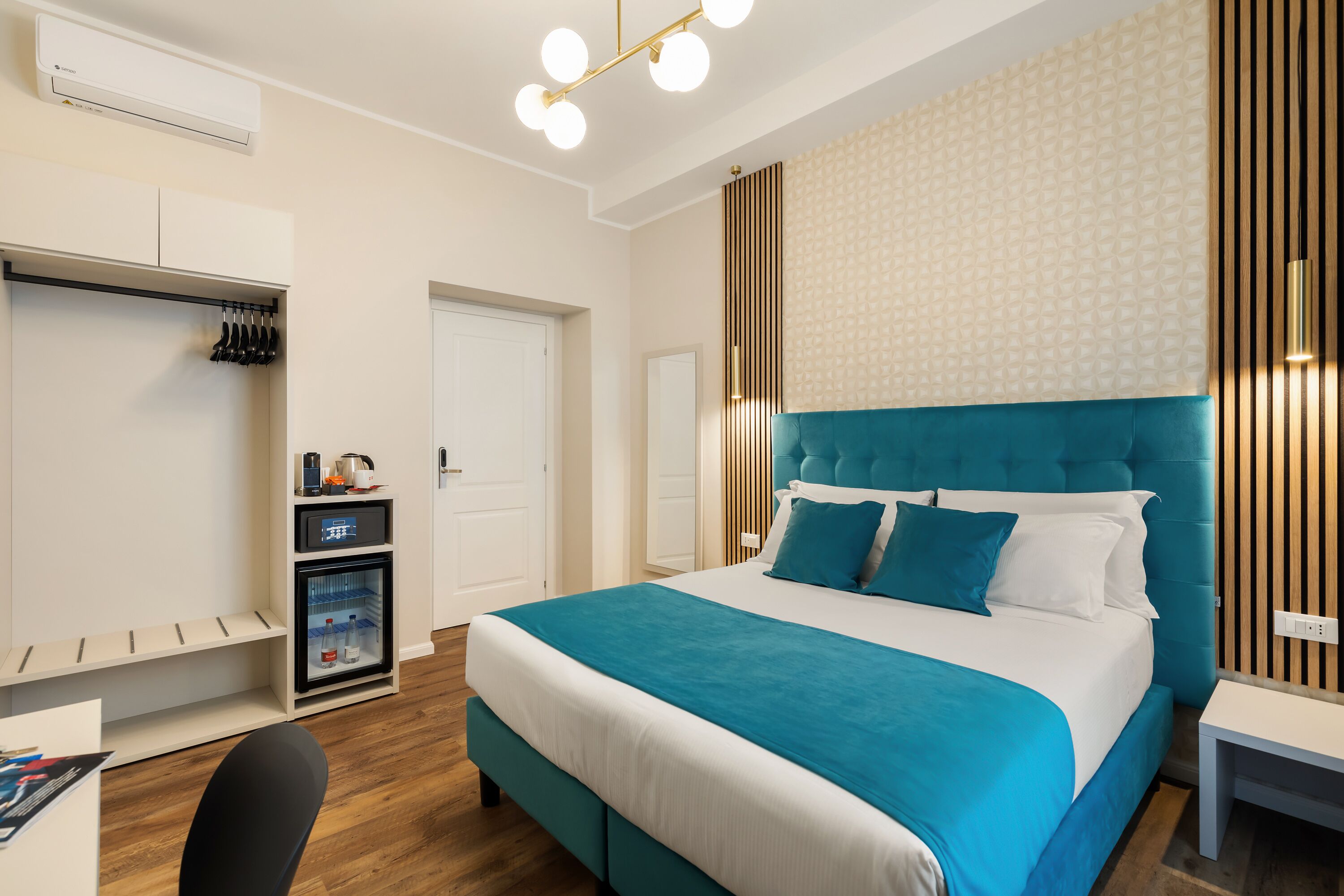 Una habitación de hotel moderna con una cama grande, un escritorio, un armario y un mini refrigerador incorporado.