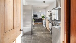 Eine moderne Küche mit Kochinsel, integrierten Geräten und einer Essecke mit einer Couch.