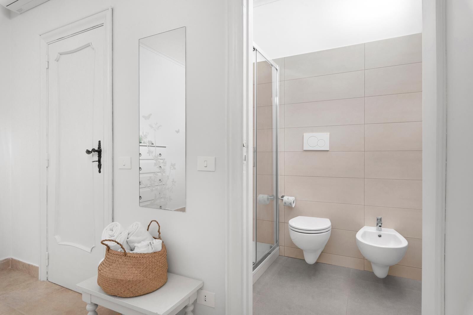 A bathroom with a toilet, bidet, and a glass shower enclosure.