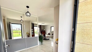 Un vaste espace de vie au design moderne, comprenant une grande fenêtre, un canapé et une table basse.