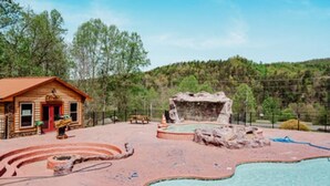 A rustic cabin with a swimming pool, surrounded by a natural landscape. - Beary Cozy Den (Gatlinburg)