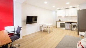A compact living space with a dining area, kitchenette, and a TV mounted on the wall. - Old Town • Santes Creus - Unik Vacation (Tarragona)