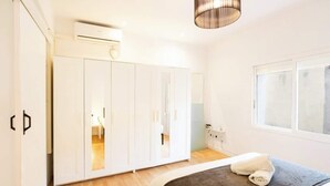A bedroom with a bed, a wardrobe, a window, and an air conditioning unit. - Old Town • Santes Creus - Unik Vacation (Tarragona)