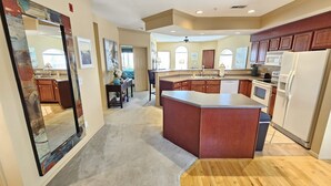 A spacious kitchen with wooden cabinets, a large island, and a view into the dining area. - Captains Quarters Walk-in Suite at the Legacy at Thousand Hills! Great Rates! (Branson)
