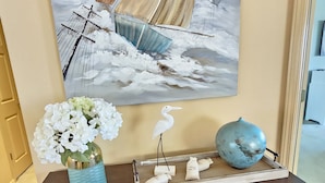 A wooden console table with a vase of white flowers, a blue ceramic pot, and decorative items. - Captains Quarters Walk-in Suite at the Legacy at Thousand Hills! Great Rates! (Branson)