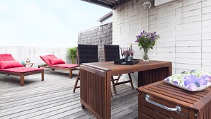 A wooden deck with a table, two lounge chairs, and a small cabinet. - My Space Barcelona Park Putxet Rentals (Barcelona)