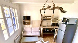A compact living space with a kitchenette, a sofa, a dining table, and a lounge chair. - Appartement Laura. Terrasse, vue mer (Le Rove)