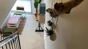 A staircase with a railing, a small table with chairs, and hanging plants. - 207 - Apartamento Tarifa Sun (Tarifa)