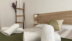 A neatly made bed with white towels, a wooden ladder, and a bedside lamp. - 207 - Apartamento Tarifa Sun (Tarifa)