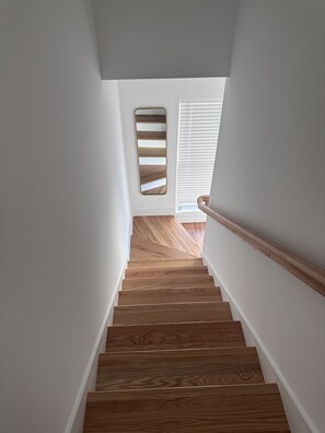A wooden staircase with white walls and a wooden handrail. - Popular Southside Chattanooga Townhouse! Dog friendly!! (Chattanooga)