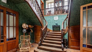 Una imponente escalera de madera con barandillas y un diseño curvo, que conduce a un piso superior.