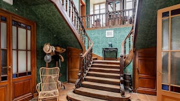 Un magnifique escalier en bois, doté de rampes et d’une forme incurvée, menant à l’étage supérieur.