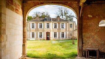 Un portail en arc donnant sur une cour intérieure, avec un bâtiment visible au fond.