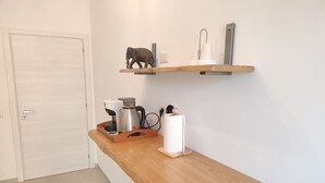 A kitchen with a wooden countertop, a kettle, a coffee maker, and a paper towel holder. - Sunnyhome- Ostia Lido sea view | 2 bathrooms (Lido di Ostia)