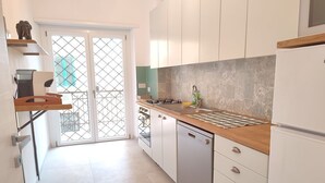 A modern kitchen with white cabinets, a wooden countertop, and a dishwasher. - Sunnyhome- Ostia Lido sea view | 2 bathrooms (Lido di Ostia)