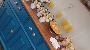 Una encimera de cocina con diversos alimentos y un armario azul con pomos decorativos.