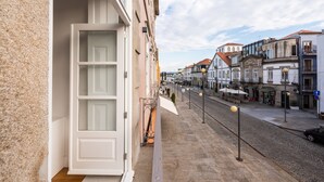 Una calle estrecha flanqueada por edificios, con un camino adoquinado y algunas zonas de estar al aire libre.