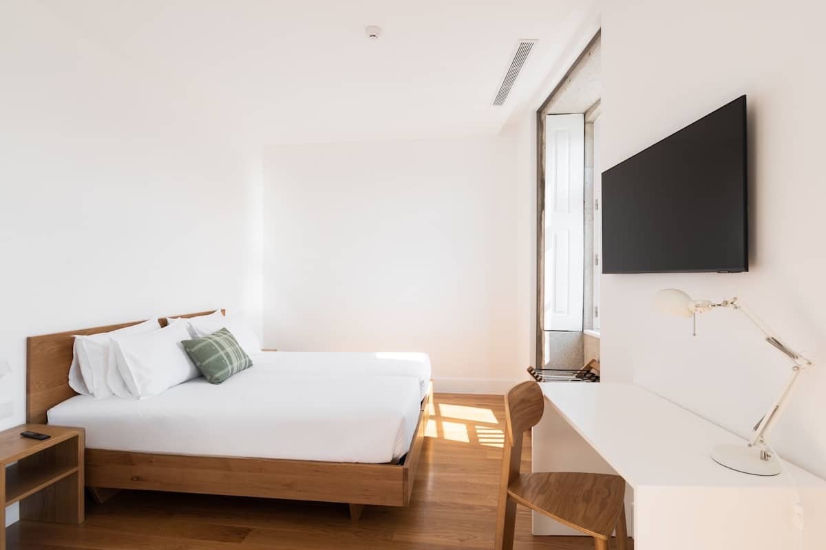 Un dormitorio con cama, escritorio y silla.