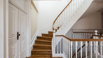 Una escalera de madera con balaustres blancos que conduce a un piso superior.