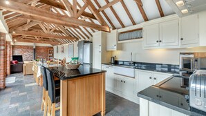 A spacious kitchen with wooden beams, a central island, and modern appliances. - 5 bedroom accommodation in Thorpe Culvert, near Skegness (Thorpe Culvert, near Skegness)