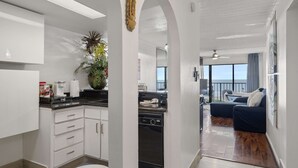 A modern kitchen with white cabinets, a black oven, and a potted plant. - Bello condominio con vista al mar, jacuzzi interno y una ubicación privilegiada (Galveston)