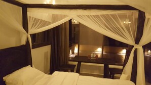 A room with a bed, a table, and a view of the outside. - Palega Beach Inn (Boneza)