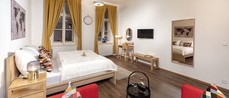 Una habitación de hotel moderna con una cama, un escritorio, una silla y un sofá rojo.