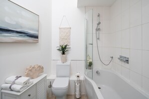 Enjoy a refreshing shower or soak in the standalone bathtub in this stylish bathroom.