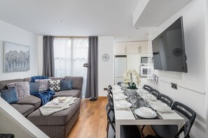 Relax in this stylish living space with a sofa, flat-screen TV, and dining area.