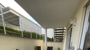 A covered patio area with a table and chairs, a potted plant, and a window with a view of the sky. - Traumhafter Lieblingsplatz in Pfullendorf am Nördlichen Bodensee (Pfullendorf)