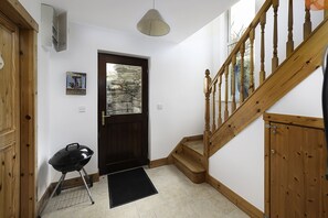 A staircase with wooden railings and a black doormat at the base. - Rhea Holiday Home Bantry (Kilcrohane)
