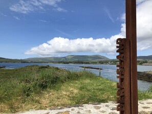 A scenic view of a lake with mountains in the background and a metal sign with the text "BERNE". - Rhea Holiday Home Bantry (Kilcrohane)