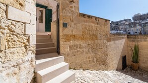 Un edificio de piedra con una escalera que lleva a una puerta con un cerrojo verde.