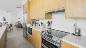 Una cocina moderna con armarios de madera, electrodomésticos de acero inoxidable y encimera de mármol.