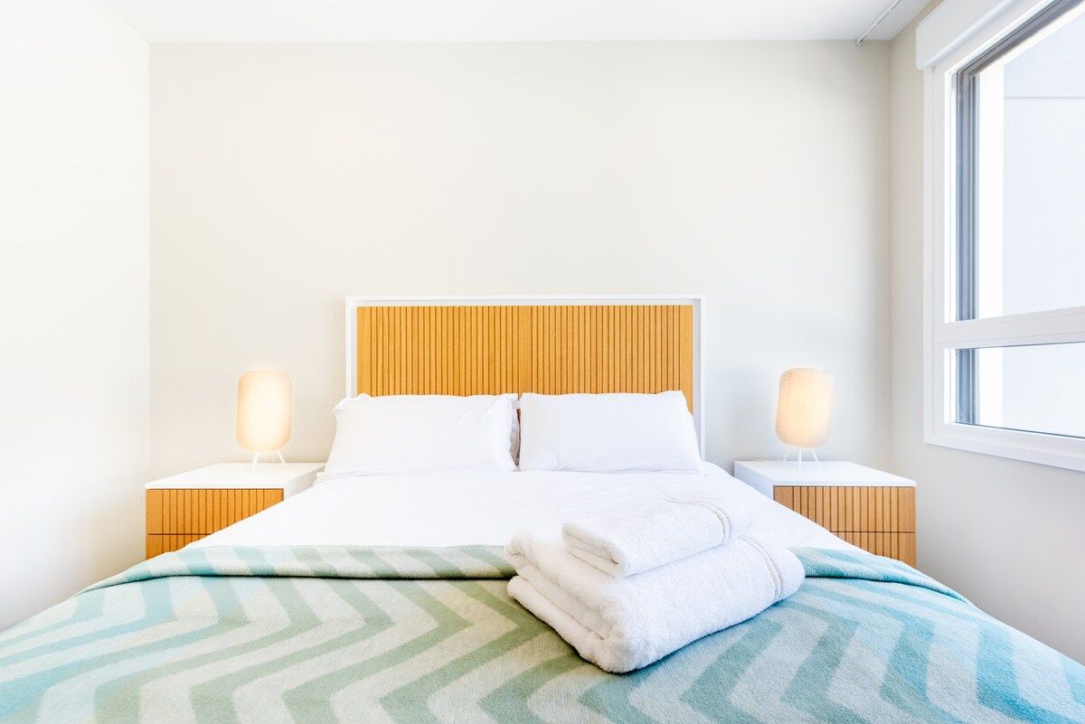 Ein Hotelzimmer mit einem Bett, zwei Nachttischen und einem Fenster.